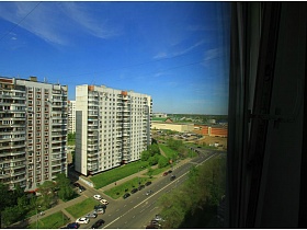 вид из окна трехкомнатной квартиры на городскую магистраль в жилом квартале с многоэтажками