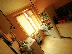 навесной шкаф над рабочей поверхностью стола в кухне с бежевыми стенами съемной квартиры