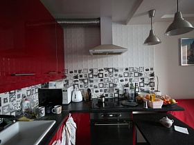 вишневая мебельная стенка с черной столешницей под мрамор, рабочей поверхностью в черно белом цвете, черным обеденным столом светлой кухни просторной квартиры