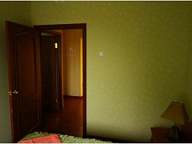 открытая дверь в спальную комнату номера с зелеными обоями