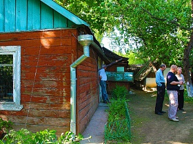 коричневая старая краска на стенах небольшой деревянной художественной дачи - музей на зеленом участке