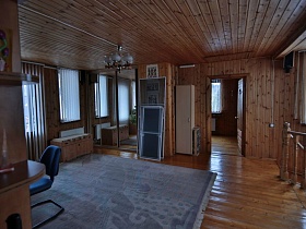 деревянный пуфик у шкафа-купе с зеркальными дверцами в просторном холле второго этажа современной деревянной загородной дачи