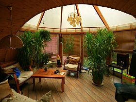 высокие комнатные цветы в больших вазонах, уютные кресла и диваны на просторном застекленном балконе с эркерными окнами под куполом на семейной классической даче