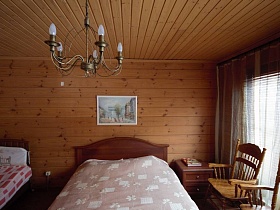 картина на стене над кроватью и прикроватная тумбочка в современной деревянной даче