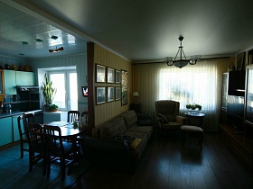 обеденный стол со стульями, голубая кухня в смежной с гостиной комнате квартиры оператора