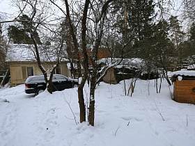черная машина на снежной дороге у домика на просторном участке деревянной дачи художника времен СССР