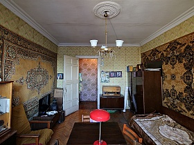 два ковра в бежево коричневых цветах на стенах с желтыми обоями в гостиной с полированой мебелью советского времени просторной трехкомнатной квартиры