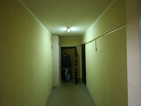 входные двери квартир в длинном коридоре на этаже современного высотного здания