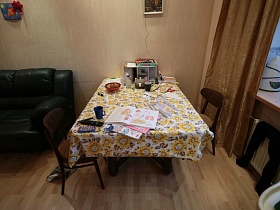 прямоугольный обеденный стол с клеенкой в гостиной в семейной трешке