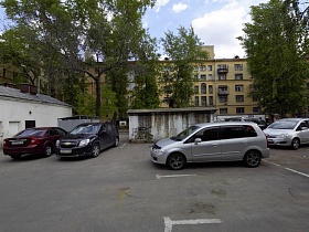 машины на площадке с парковочными местами в коммунальном дворе