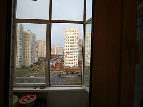 вид из открытого окна трешки на стройные жилые многоэтажки