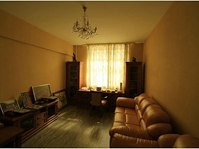 общий вид светлой гостиной с хрустальной люстрой на потолке гостиной типичной двухкомнатной квартиры