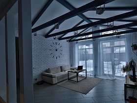 вид на просторный двор через большие панорамные окна гостиной с прозрачной гардиной скандинавской дачки для съемок кино