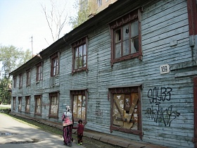 расписанные стены старого деревянного барака, окрашенного в голубой цвет с забитыми окнами на первом этаже вдоль улицы