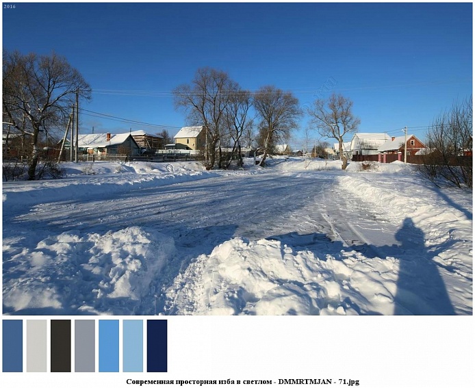 широкая расчищенная от снега  проезжая дорога в поселке с жилыми современными домами