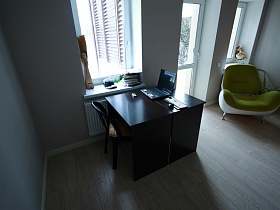 ноутбук на рабочем столе со стулом у окна