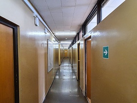 Длинный коричневый коридор с верхними окнами