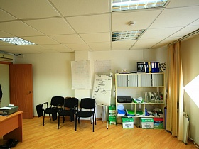 рядовой офис с белыми стенами, белым потолком и белым открытым шкафом