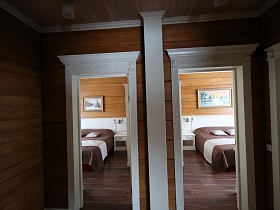 открытые двери просторного холла в спальные комнаты съемного коттеджа
