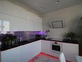 серебристая зеркальная мозаичная рабочая поверхность белой кухни с сиреневой подсветкой в современной лаконичной квартире в стиле хай-тек