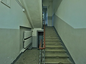 бетонные ступени высокой лестницы, требующей ремонта в сером подъезде жилого дома эпохи СССР