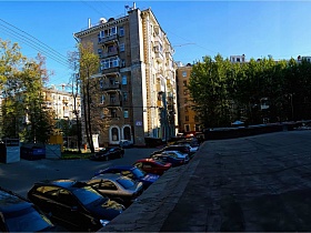 общий вид старого кирпичного сталинского дома с арками