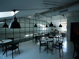 большие черные люстры в стиле  лофт на белом потолке с мансардными окнами стильного кафе в БЦ