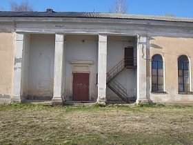белые колоны в нише светло-розового здания с коричневой дверью выхода из зала кино и железной пожарной лестницей старого клуба советского времени