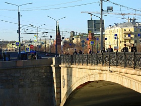 многочисленные синие дорожные знаки, тротуар для пешеходов на Малом Каменном автомобильном мосту с чугунными резными перилами с видом на Кремль для съемок кино