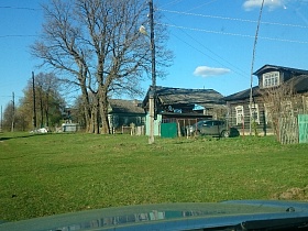 почтовый ящик на зеленом деревянном заборе, машина за сетчатым забором с металлическими зелеными воротами жилых домов вдоль широкой улицы старой деревне 2