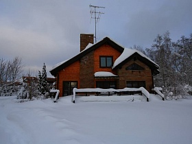 много снега вокруг современной деревянной дачи