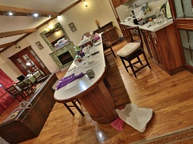 светлые столешницы мебельной кухни, барной стойки и высокого шкафа в отдельной зоне с островком готовки