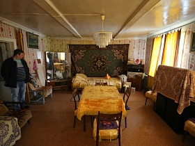 большой трельяж с зеркалом и старинный приемник на тумбочке в углах гостиной на даче эпохи СССР