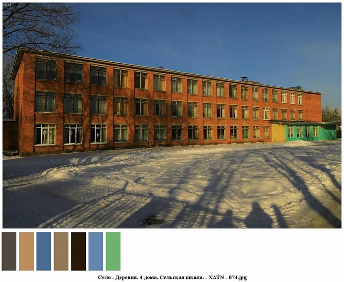 общий вид кирпичной трехэтажной сельской школы в зимнее время