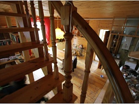 вид на гостиную со ступенек лестницы с перилами двухэтажной деревянной дачи музыканта
