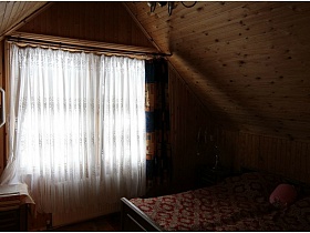 белая гардина на большом окне спальни с двухспальной кроватью на массандре бревенчатой дачи СССР