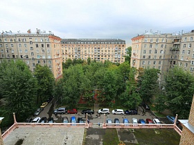 вид на соседние высотные дома с полисадниками и проезжей дорогой в жилом квартале из окна сталинского здания