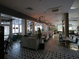 общий вид просторного зала светлого прозрачного ресторана с большими окнами на берегу озера