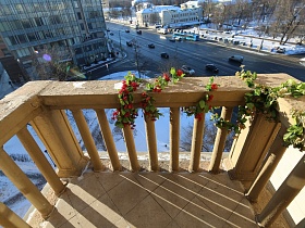 транспорт на городской широкой улице в жилом квартале Москвы с небольшого бетонного балкона с перилами жилого многоэтажного дома