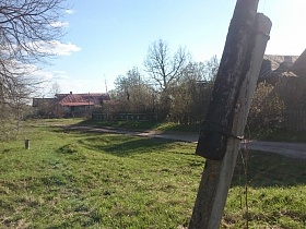 разнообразные по строению старые дома за деревянным и металлическим забором вдоль проселочной дороги в деревне 2