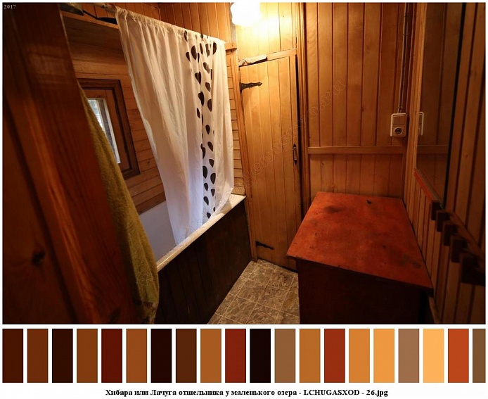 белая ванна, общитая коричневым деревом с белой шторкой , стол у стены в деревянной комнате небольшого жилого домика отшельника среди новостроек