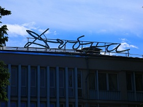 название гостиницы "Дубна" из светодиодных труб на крыше пятиэтажного здания эпохи СССР