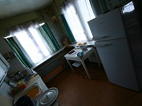 посуда на обеденном столе и кастрюли на газовой печке у окон с широким подоконником на кухне дачи СССР