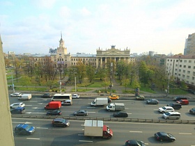 оживленная автомагистраль с двухсторонним движение в восемь полос в жилом квартале из окна квартиры сталинки