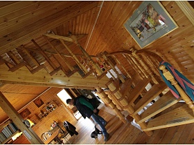 картина на стене над витой лестницей с резными перилами в двухэтажной деревянной даче музыканта