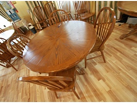 стулья со спинкой вокруг круглых столов на полу с коричневым линолеумом  уютного летнего кафе с большими панорамными окнами