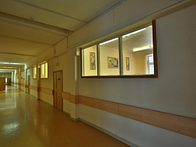 длинный белый коридор со множеством классов в красивой школе