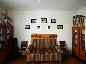 полосатый диван со стульями у стены между шкафами для книг