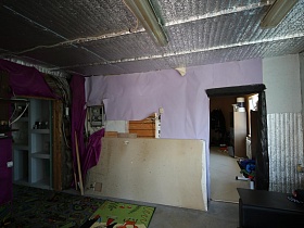 утепленный потолок, встроенные белые шкафы в недостроенной комнате уютной семейной дачи с видом на город