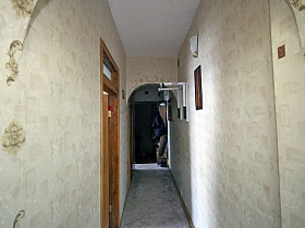 белый потолок, светло серые стены и серый под мрамор линолеум на полу длинного коридора просторной классической трехкомнатной квартиры в сталинском доме
